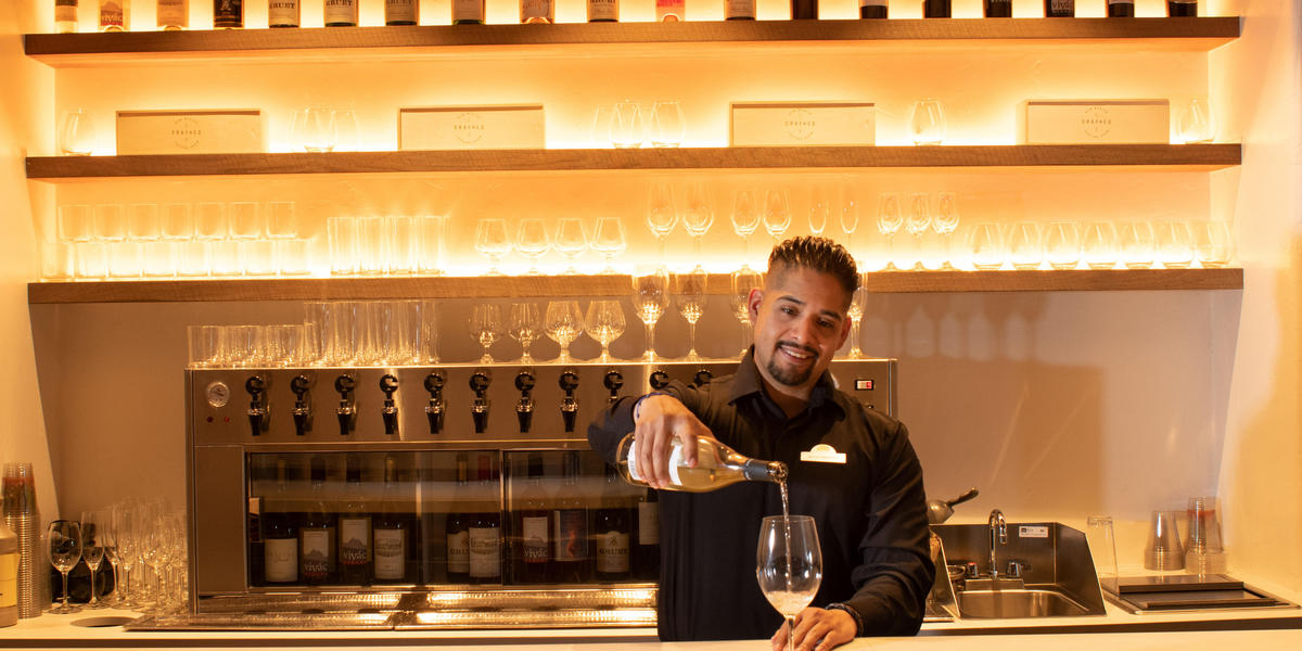 Bartender pouring wine in Crafted